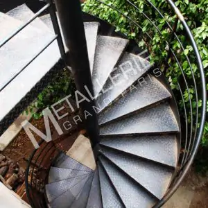 Escalier extérieur métallique de forme hélicoïdale au design contemporain industriel pour accès terrasse.