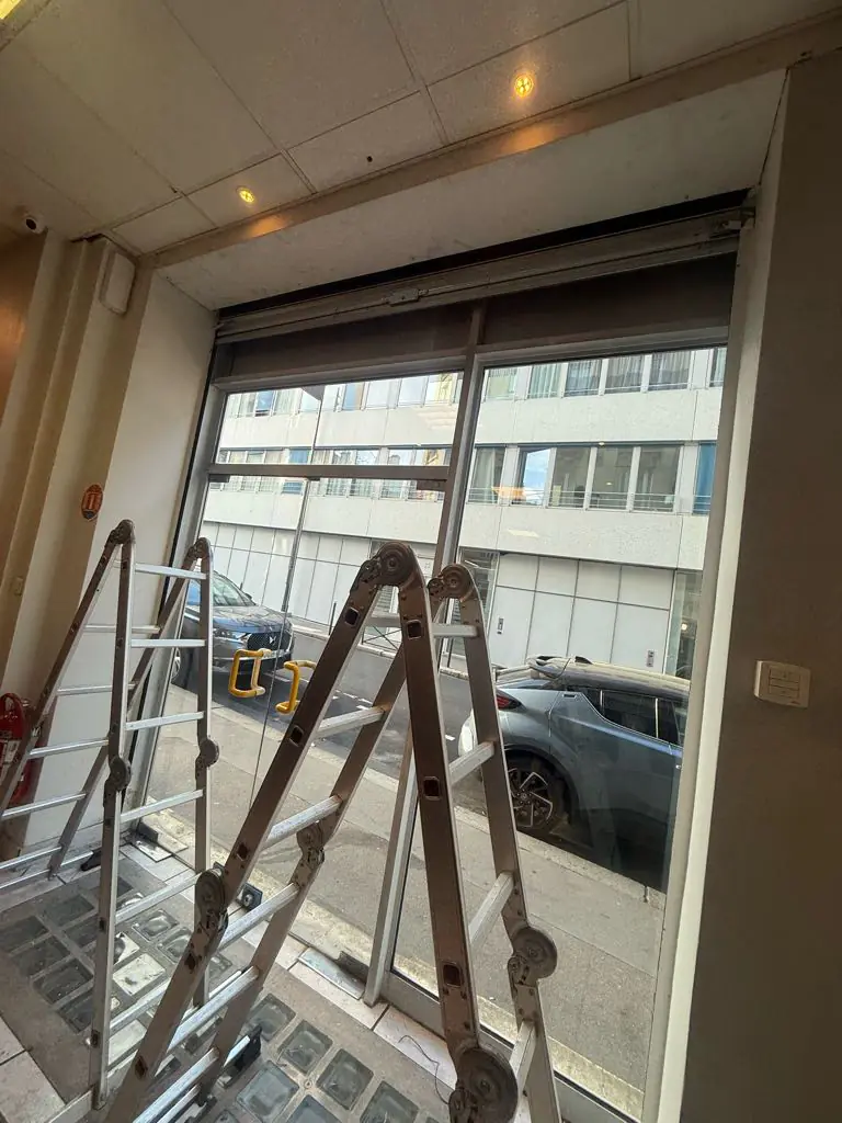 Dépannage rideau métallique bloqué Aubervilliers : un technicien qualifié MGParis intervient en urgence pour une réparation de moteur sur un rideau à lames galvanisées dans un garage.
