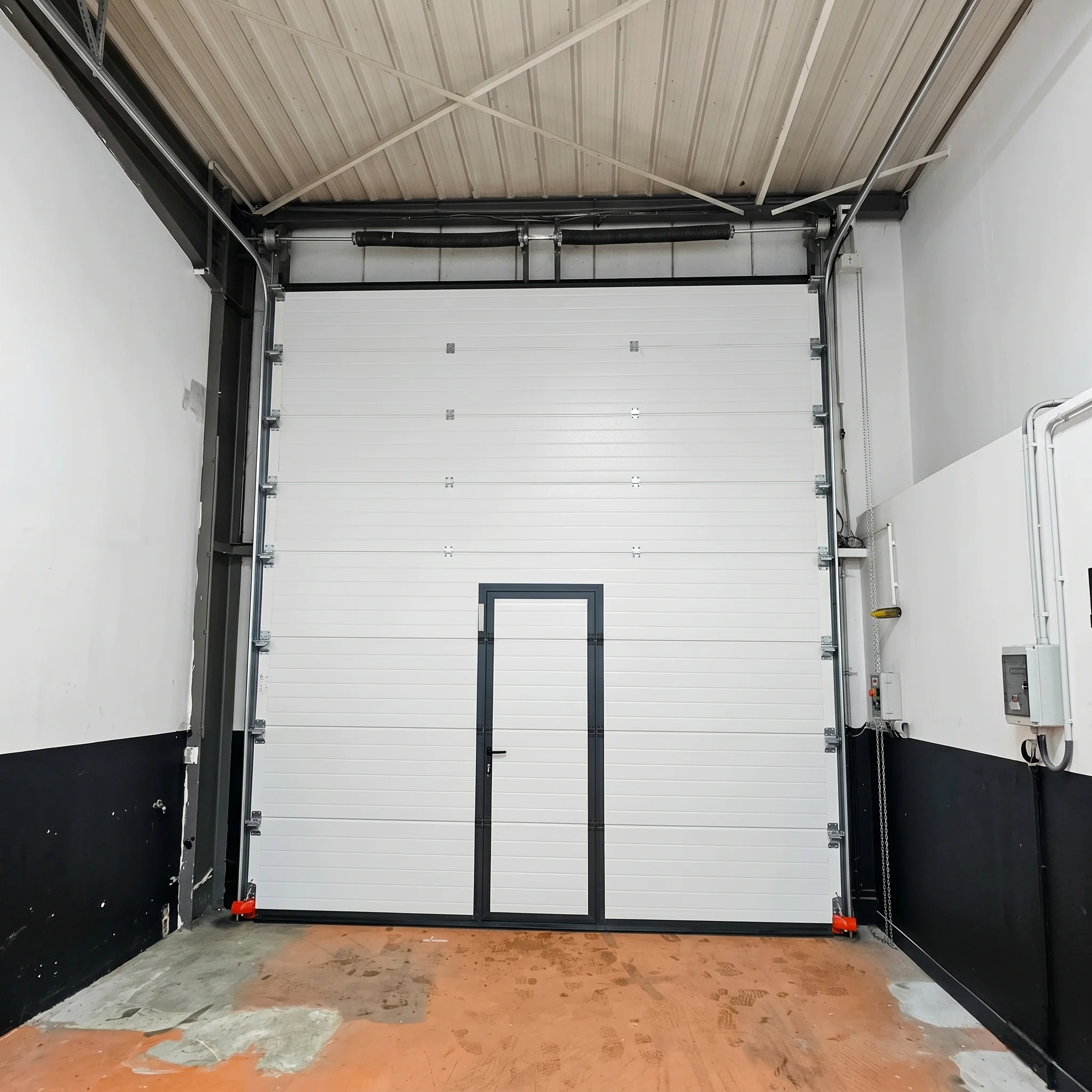Porte sectionnelle industrielle avec portillon integré