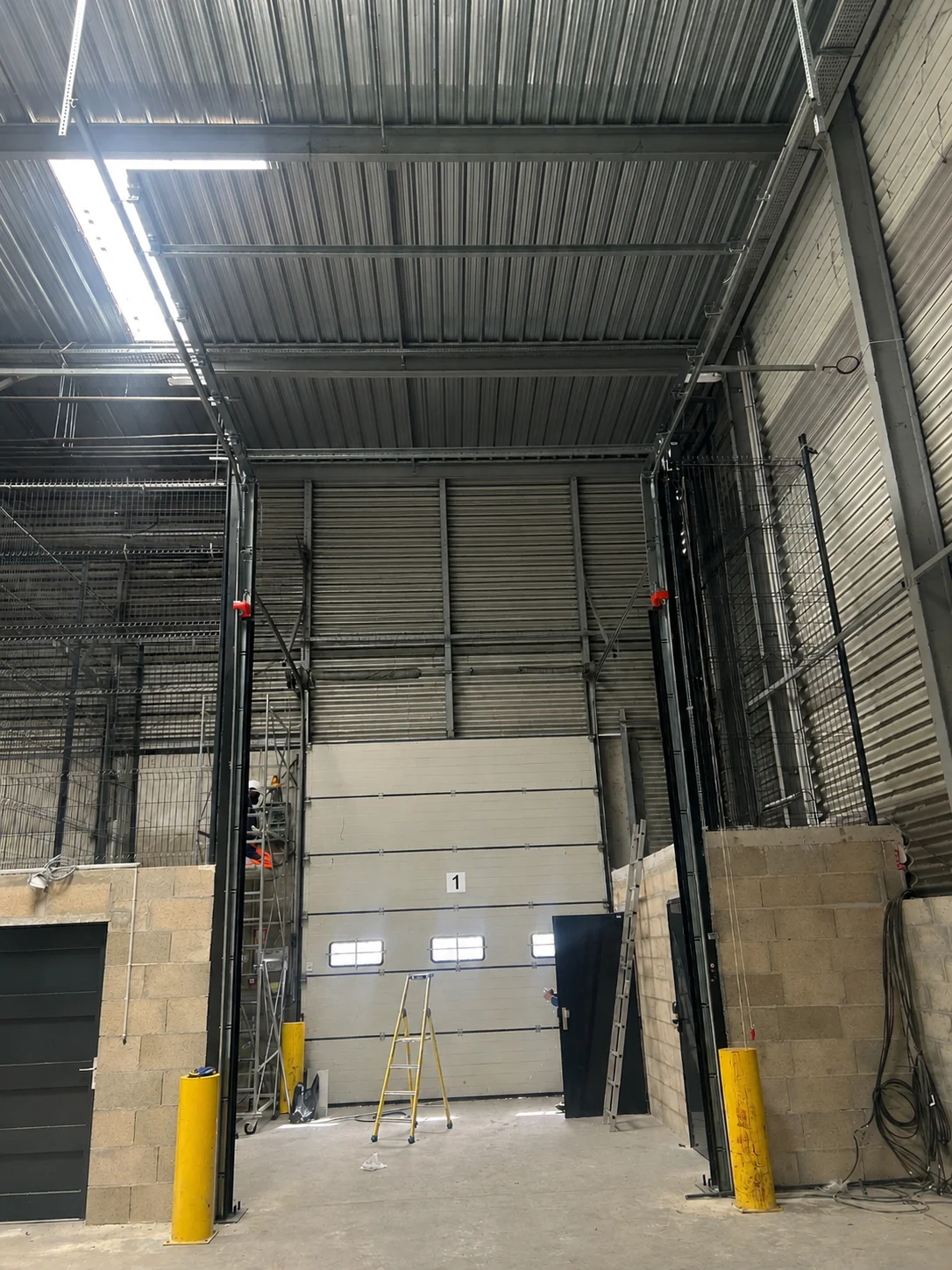 Accès avant pose d'une porte sectionnelle industrielle motorisée avec portillon à Bonneuil-sur-Marne 1