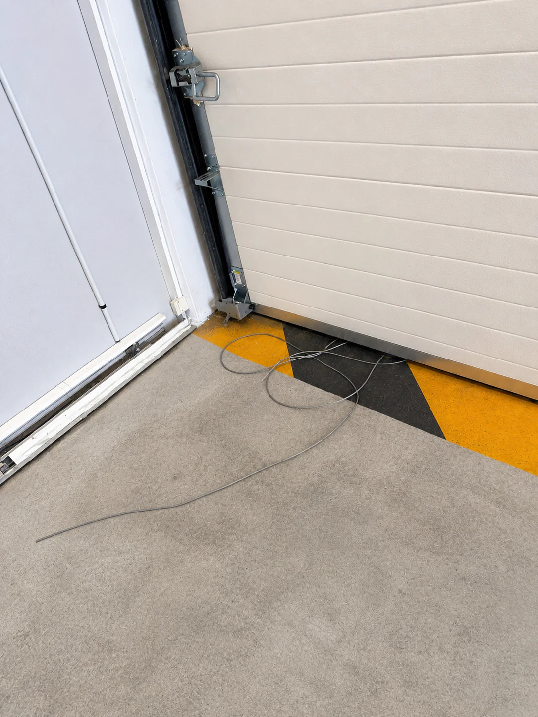 Porte sectionnelle industrielle fonctionnelle après remplacement de la paire de câbles de levage à Bagnolet 93170.