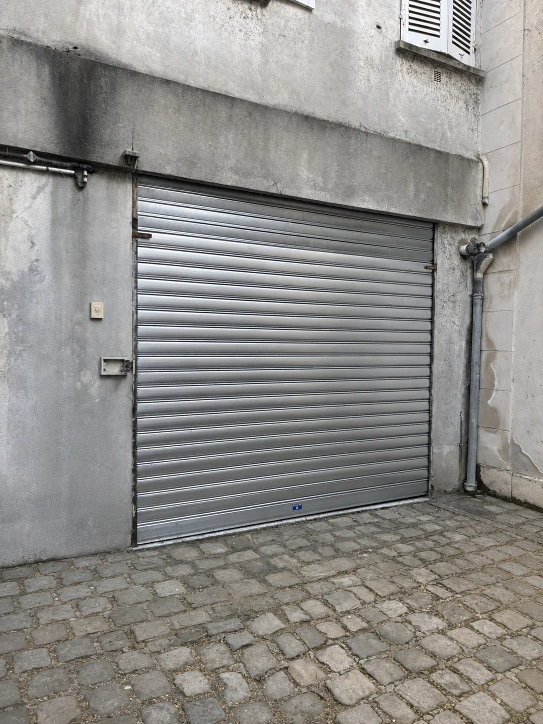 Nouveau rideau métallique motorisé en tunnel intérieur avec lames pleines et microperforées installé à Versailles (78000) après remplacement complet