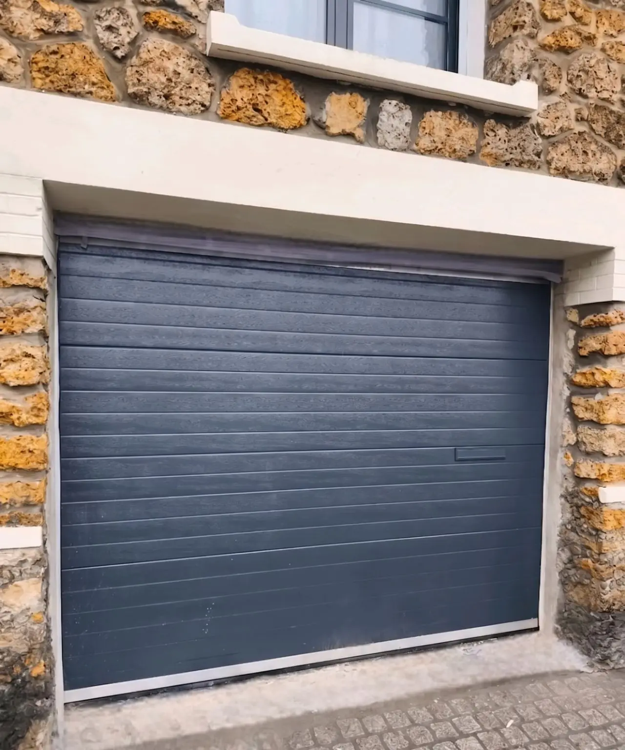 Porte sectionnelle RAL 7016 avec trappe à lettres installée à Courbevoie par MGParis