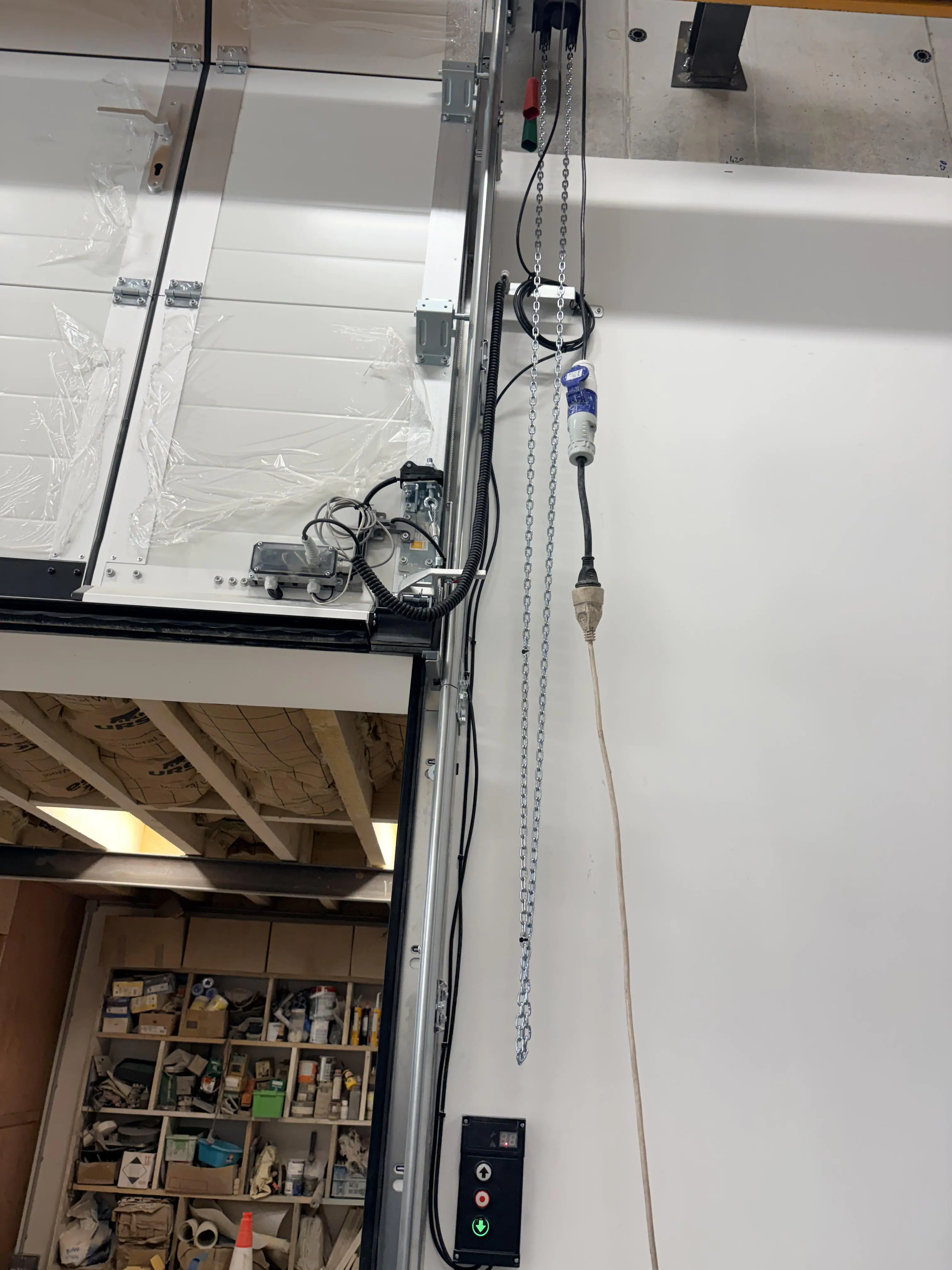 Nouvelle pièce d'accouplement installée sur une porte sectionnelle industrielle après intervention à Aubervilliers