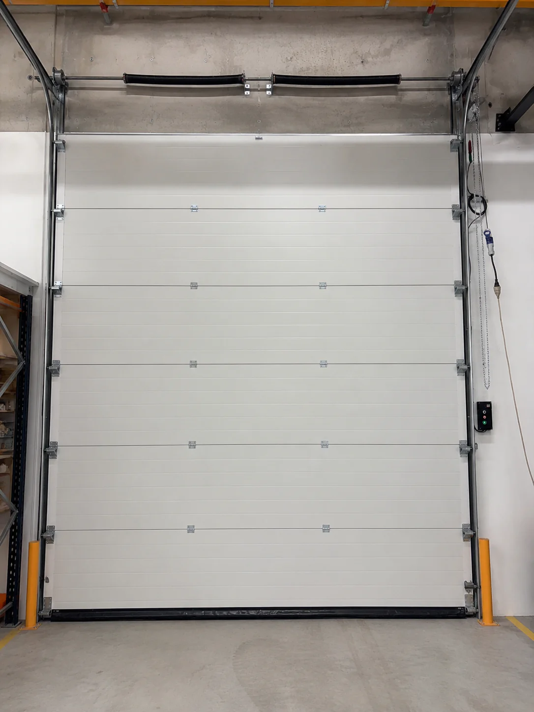 Porte sectionnelle industrielle bloquée en position fermée suite à la casse de la pièce d'accouplement à Aubervilliers