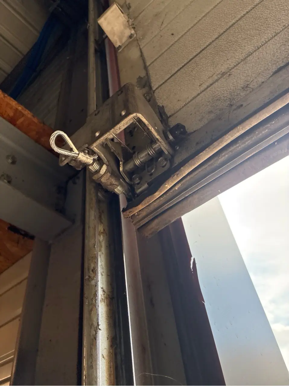 Nouveaux câbles de levage installés sur une porte de garage sectionnelle à Houdan (78550), porte fonctionnelle après réparation