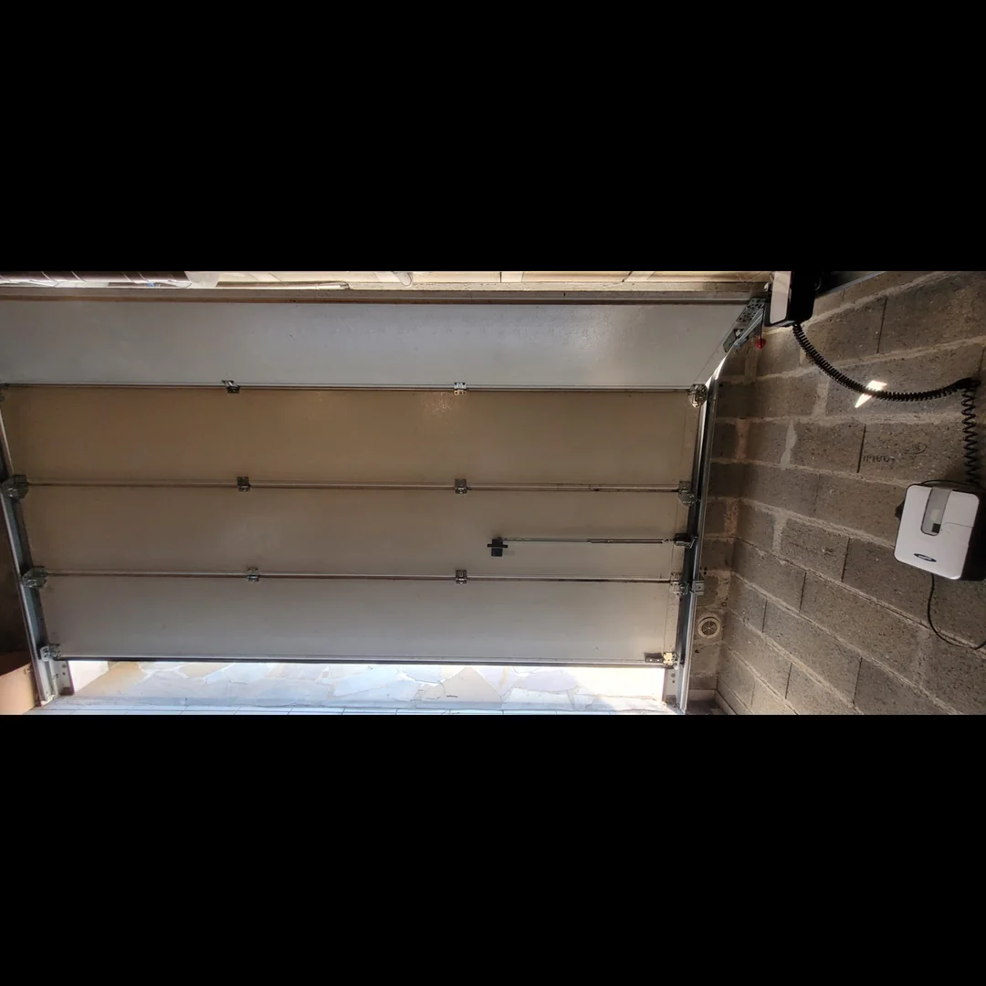 Porte de garage sectionnelle résidentielle bloquée ouverte à Villebon-sur-Yvette (91140) avant remplacement des ressorts de torsion