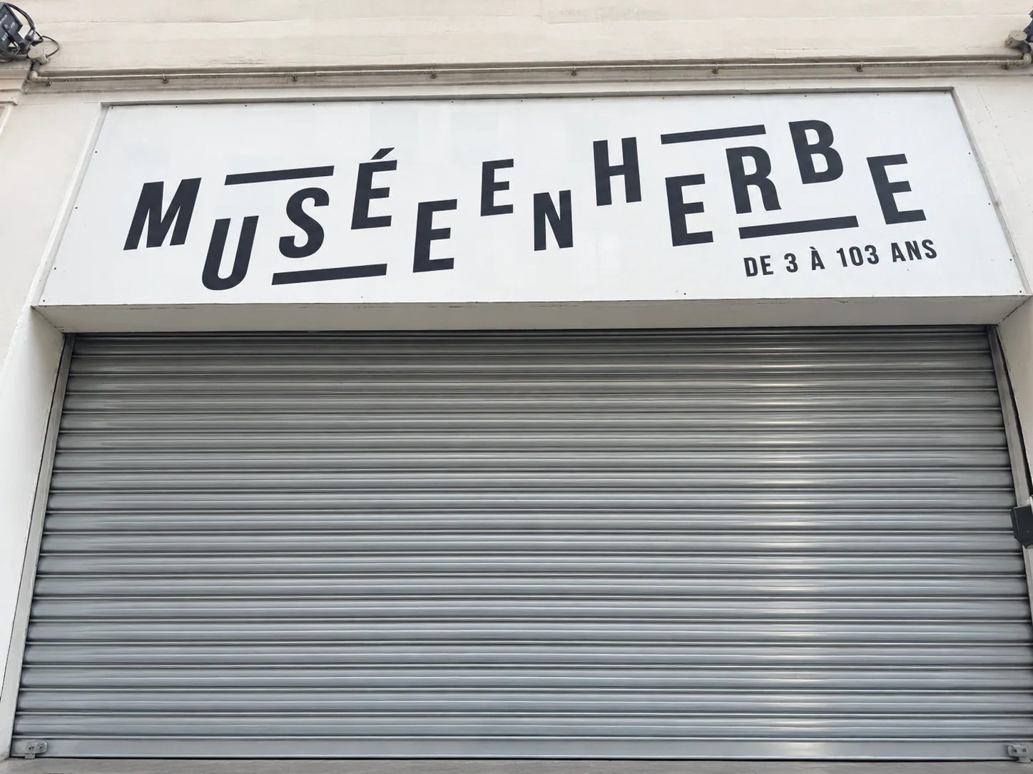 Rideau métallique à lames pleines bloqué en position fermée au Musée en Herbe à Paris 1er avant remplacement du moteur central