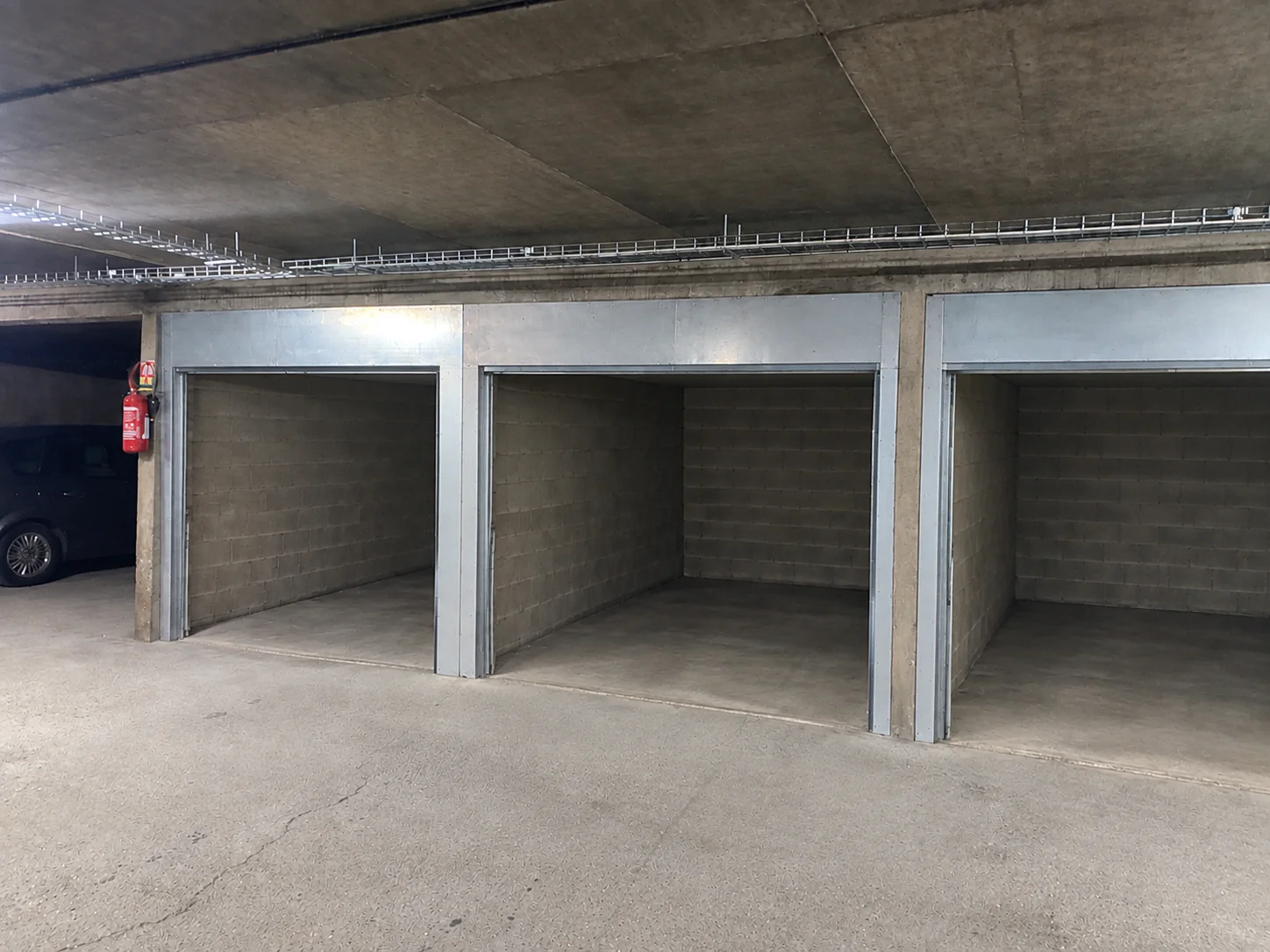 Trois espaces de garage ouverts avant l'installation de portes de garage basculantes à Arcueil 94110.