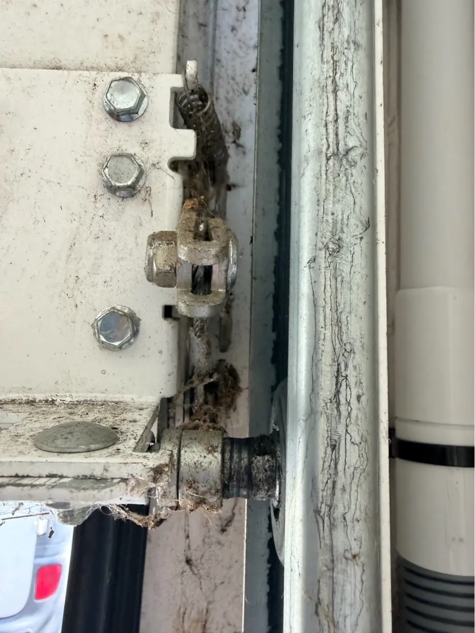 Fixation basse du câble de levage d'une porte de garage sectionnelle contrôlée lors d'une réparation à Lesches