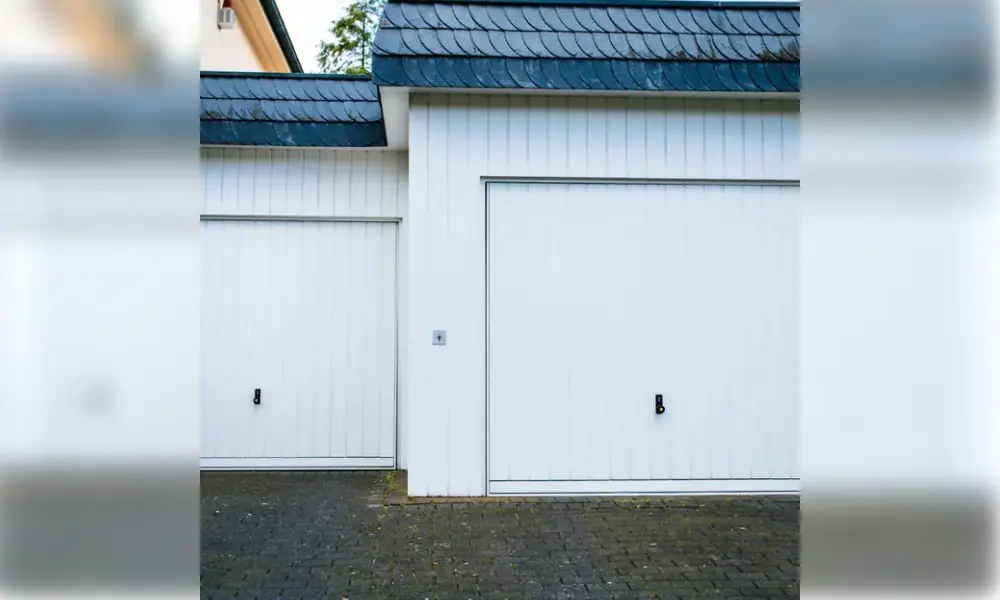 Deux portes de garage basculantes blanches côte à côte, toit d’ardoise, à Chailly-en-Brie (77120)