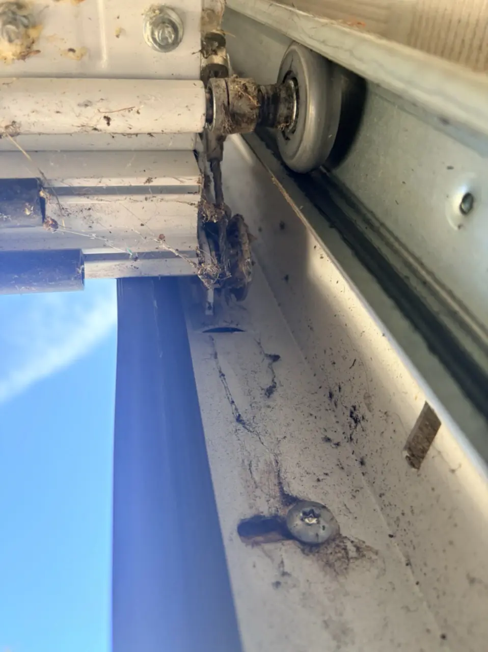 Galet et fixation du câble de levage d'une porte de garage sectionnelle contrôlés lors d'une réparation à Écharcon