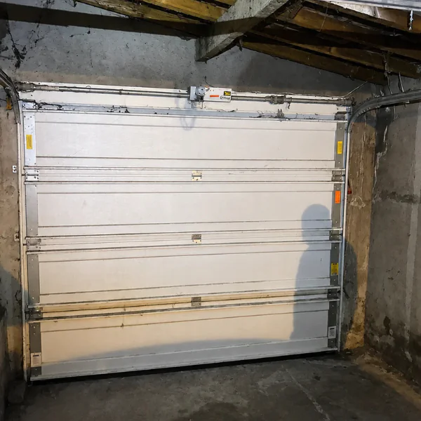 Panneaux et rails d'une porte de garage sectionnelle vus de l'intérieur : réparation à Fontaine-la-Rivière