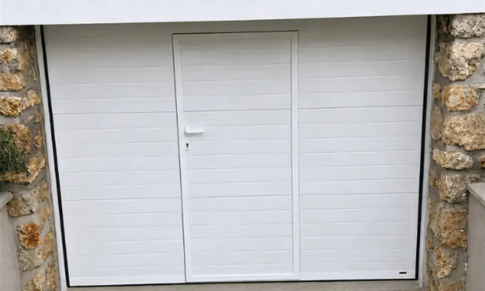 Porte de garage blanche à deux vantaux encadrée de pierre, dépannage à Armentières-en-Brie (77440)