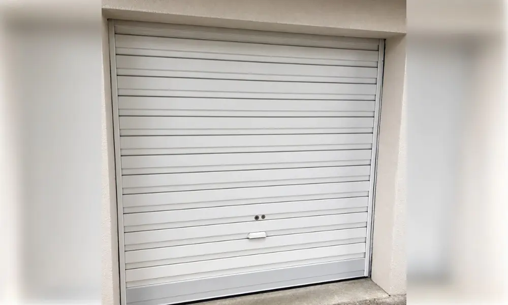 Porte de garage enroulable blanche à lames horizontales sur une façade crème, Bussy-Saint-Martin