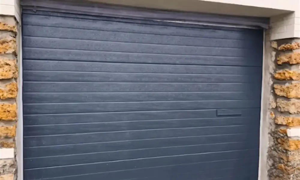 Réparation porte de garage Barcy (77910) : porte sectionnelle anthracite dans un encadrement de pierre