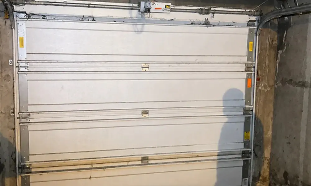 Rails, ressorts et câbles d’une porte sectionnelle de garage à Paris 15 (75015)