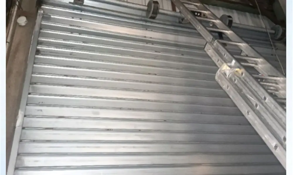 Réparateur de rideau métallique à Gometz-la-Ville (91400) : artisan MGParis au travail sur un rideau de garage