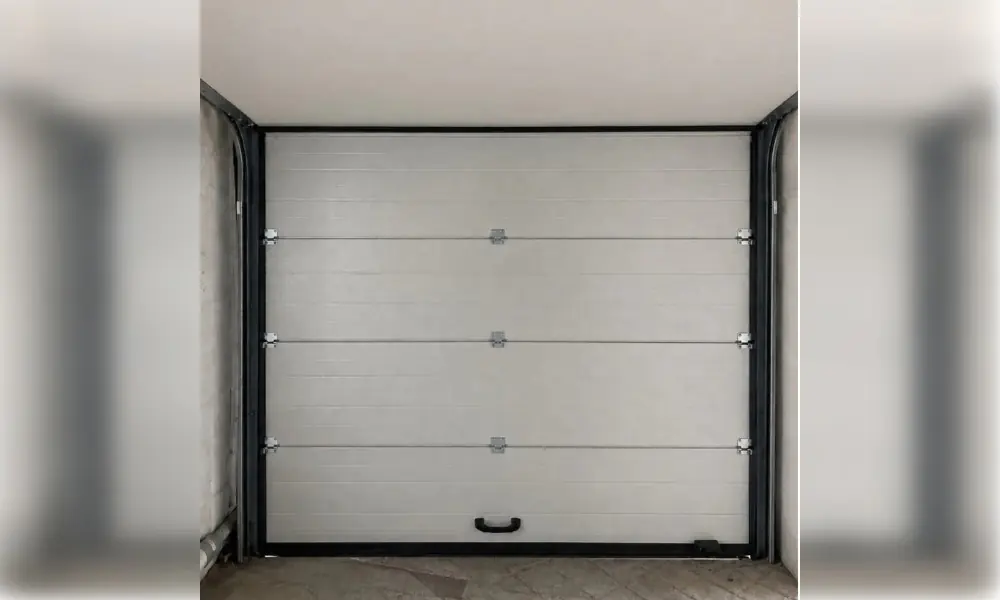 Porte de garage blanche à panneaux horizontaux et poignée noire, vue de l’intérieur à Faÿ-lès-Nemours