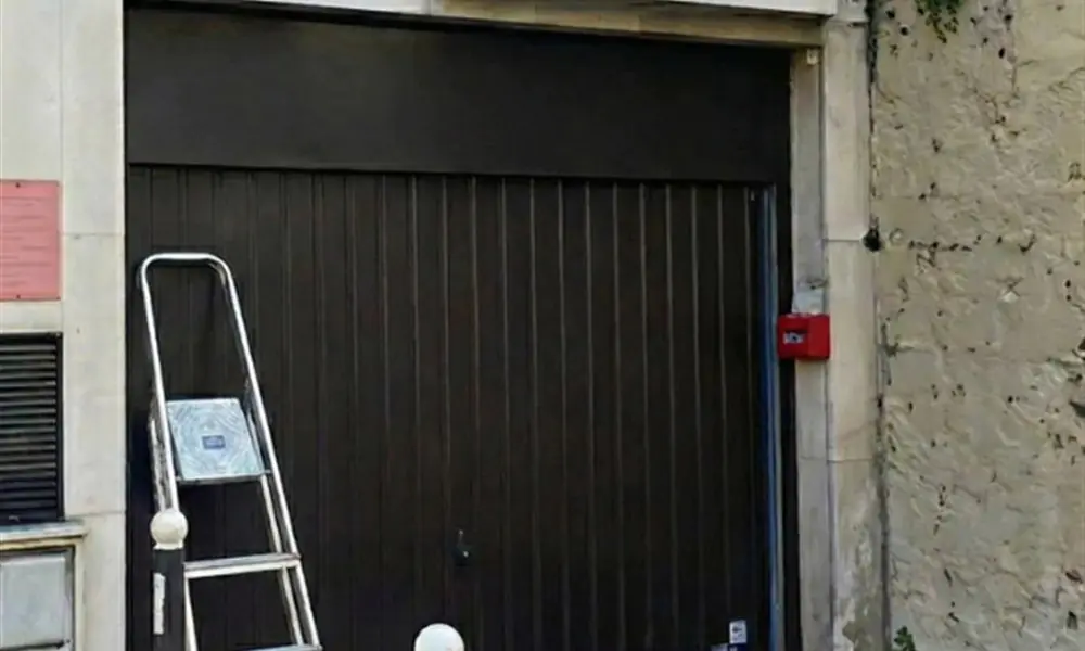 Réparation porte de garage Paris 11 (75011) : porte sombre de garage sous le porche d’un immeuble