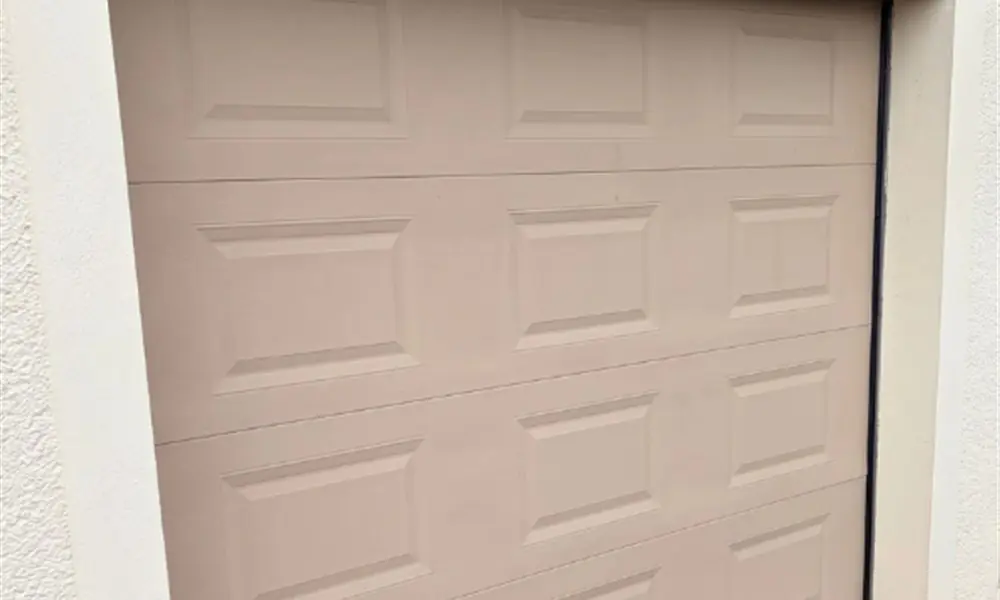 Réparation porte de garage Bassevelle (77750) : porte sectionnelle à cassettes sous une poutre