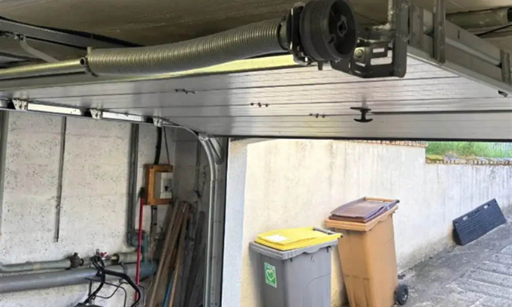 Réparation porte de garage Vauhallan (91430) : ressort de torsion et poulie d’une porte sectionnelle de garage